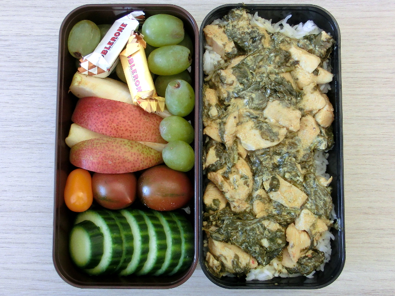 Bento Box gefpllt mit Afrikanisch inspirierte Hühnchenpfanne, Weintrauben, Apfel, Tomaten, Gurke, Toblerone