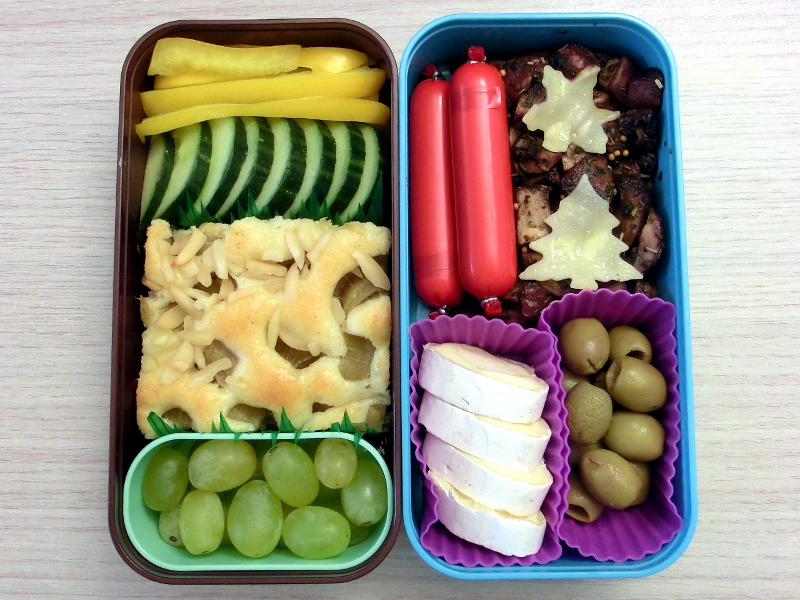 Bento Box gefüllt mit Pilze, Oliven, Käse, Paprika, Gurke, Rababer-Kuchen, Weintrauben, Fleischwurst