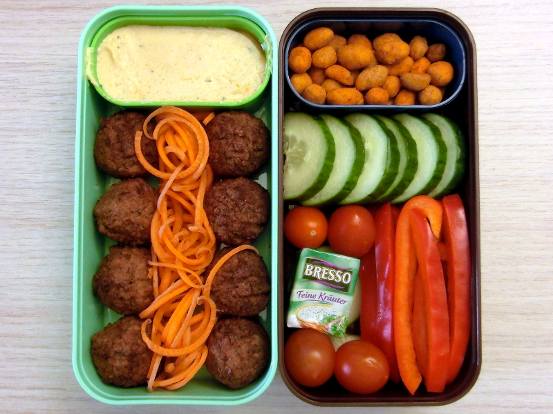 Bento Box gefüllt mit Falafel, Dipp, Möhren, Erdnüsse, Gurke, Tomaten, Paprika, Käse
