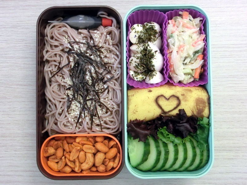Bento Box gefüllt mit Soba, Erdnüsse, Cole Slaw, Morzarella, Banane, Gurke